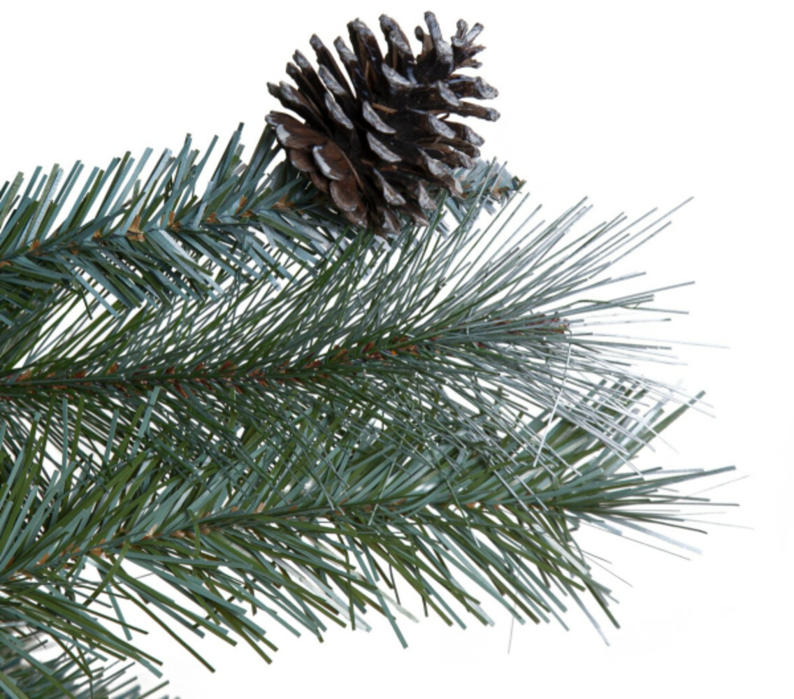 Prachtvoll geschmückter, tiefgrüner Weihnachtsbaum von Star Trading mit schneebedeckter Spitze und hängenden Tannenzapfen