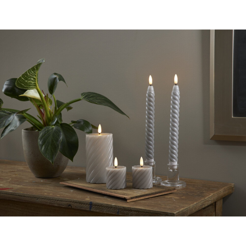 Detaillierte Aufnahme einer LED Kerze von Star Trading im Spiraloptik Design, grau und eingetaucht in natürlich wirkendes Kerzenwachs