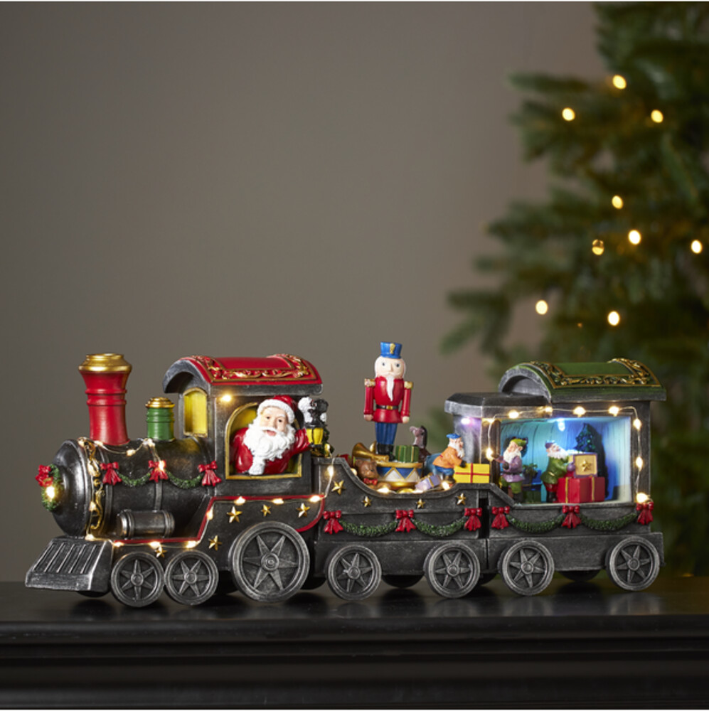 Ein farbenfroher Zug der Marke Star Trading, dekorativ beleuchtet durch 46 warmweiße LEDs, ideal für eine weihnachtliche Szene